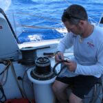 Pepe Ribes repara un dels winches primaris durant la Barcelona World Race Pepe Ribes repara un dels winches primaris durant la Barcelona World Race