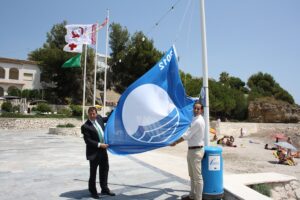 El batle i el regidor de medi ambient hissen la bandera blava a la platja de la Fustera de Benissa