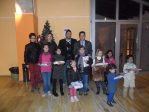 Els xiquets guanyadors dels concursos de Relats Curts de Nadal i de Targetes Nadalenques de Benissa amb el batle i els regidors