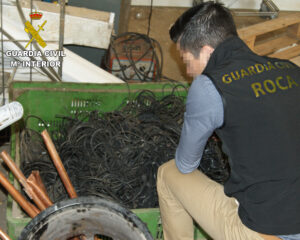Un agent de la guàrdia civil inspecciona part del cable de coure furtat