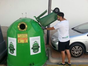 Un xic aboca el vidre en un contenidor