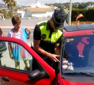 Un policia local de Benissa enganxa l'adhesiu a un vehicle d'una resident