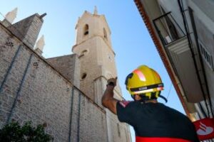 Un bomber observa el campanar de l'església de Benissa